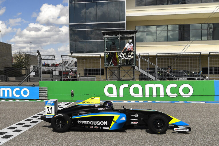 CHRISTIAN WEIR STANDS ON PODIUM AT THE CIRCUIT OF THE AMERICAS